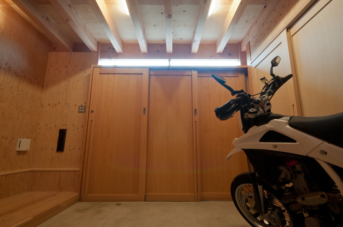 神戸町の家　玄関は３枚の引き戸で写真右側に引き込んで開放できます。ハイサイドから差し込む光で昼間は照明がいりません